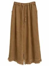 Pantalón ancho color camel de lino, con cintura elástica con cordón ajustable y detalle de flecos en el ruedo.