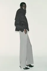 Pantalón recto color marrón oscuro, de tiro medio, con cintura elástica en la espalda, bolsillos delanteros de vivo y cierre frontal con cremallera, botón interior y gancho.