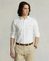Camisa blanca de corte clásico, confeccionada en tejido oxford de algodón. Presenta cuello button-down, manga larga con puños abotonados y logo bordado en el pecho.