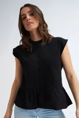 Camiseta sin mangas negra con cuello redondo, hombros estructurados y un volante peplum en la parte inferior.
