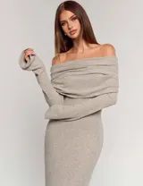 Vestido largo de punto acanalado en color beige, con diseño de hombros descubiertos y cuello solapado. Presenta mangas largas y un corte ajustado al cuerpo.