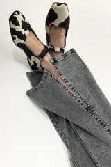 Pantalón jean gris de tiro medio alto, corte wide leg con tajo frontal.