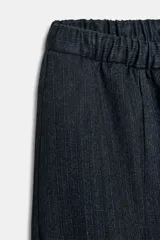Pantalón de tiro medio con corte wide leg y cintura elástica ajustable. Presenta bolsillos laterales ocultos en las costuras y un diseño de pierna ancha con caída fluida.
