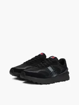 Zapatillas Tommy Jeans de corte bajo, color negro, con exterior de ante y detalles distintivos de la marca.