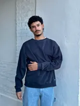 Buzo de cuello redondo y manga larga, confeccionado en algodón, con diseño liso y ajuste holgado.