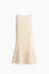 Vestido corto de crochet color beige, sin mangas, con escote redondo y diseño ligeramente acampanado en el bajo.