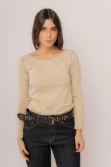 Remera de manga larga color beige con cuello redondo y costuras visibles en contraste. Confeccionada en algodón suave, presenta un diseño básico y versátil.