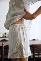 Shorts de tiro medio y cintura elástica, confeccionados en hilatura con mezcla de viscosa. Presentan diseño fluido y detalles de encaje bordado a contraste en los laterales.