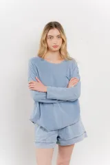 Remera manga larga color rosa con bolsillo en el pecho y corte irregular en el ruedo.