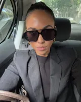 Lentes de sol con armazón de policarbonato negro y cristales tonalidad ámbar, con diseño de puente doble estilo aviador.