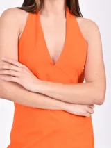 Vestido corto negro con escote halter y espalda descubierta, confeccionado en tela ligera.