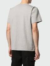Remera de algodón gris con cuello redondo y mangas cortas. Presenta el logo de la marca estampado en color blanco en el frente.