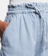 Short de jean celeste, modelo runner, con cintura elástica, cordón para ajuste, bolsillos y rayado en hilo teñido.