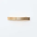 Pack de dos pinzas para el cabello en tono dorado, una con diseño de líneas paralelas y otra con textura martillada.