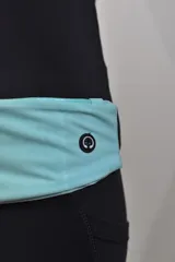 Riñonera deportiva negra con cierre superior y banda elástica ajustable con detalle reflectivo.