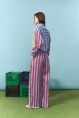 Pantalón de corte recto y tiro medio, confeccionado en algodón con estampado de rayas verticales en tonos rojo y azul. Cuenta con cintura elástica con cordón de ajuste.
