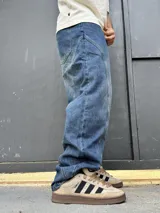 Pantalón de denim azul con diseño balloon y costuras curvas decorativas en las piernas.