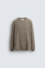 Jersey de punto con diseño de trenzas verticales, cuello redondo y manga larga. Presenta un ajuste regular y acabados en rib en cuello, puños y ruedo.