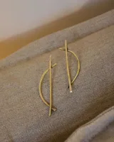 Aros colgantes de bronce dorado con diseño geométrico minimalista.