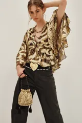 Camisa de lurex con estampado animal print en tonos dorados y marrones, con escote en V y mangas largas con volados amplios.