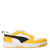 Championes Puma Rebound V6 Low de estilo urbano, con diseño de bloques de color en amarillo, blanco y negro. Presentan una parte superior de cuero sintético con perforaciones en la puntera, cierre de cordones y suela de goma con amortiguación en el talón.