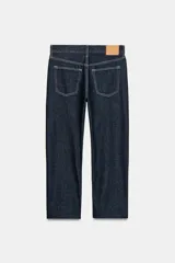 Jeans de tiro medio con corte recto y largo al tobillo. Presentan diseño de cinco bolsillos, cierre frontal con cremallera y botón, y ruedo deshilachado.
