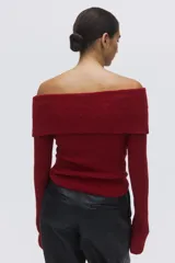 Buzo de punto acanalado color rojo, con escote off-the-shoulder y detalle de nudo frontal.
