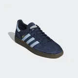 Championes Adidas Handball Spezial, color azul marino con detalles en celeste y suela marrón. Confeccionados en gamuza con las tres tiras clásicas de Adidas en los laterales y el nombre del modelo en dorado.