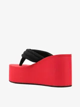 Sandalias de plataforma alta con cuña en color rojo, con tiras acolchadas estilo ojota en color negro y parche con el logo de Coperni.