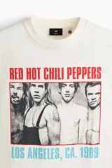 Remera de algodón color beige con diseño estampado de la banda Red Hot Chili Peppers, de corte oversized y mangas cortas.