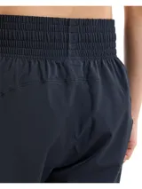 Pantalón deportivo Under Armour de corte al tobillo, color negro, con cintura elástica de talle alto y cordón interno. Presenta bolsillos laterales y detalles reflectantes en los laterales de las piernas.