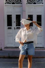 Cinturón de cuero negro con hebilla metálica circular plateada y diseño minimalista.