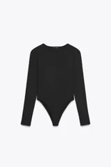 Body de manga larga y cuello redondo, confeccionado en tejido de mezcla de poliamida. Presenta un diseño ajustado con cierre inferior mediante botones a presión.