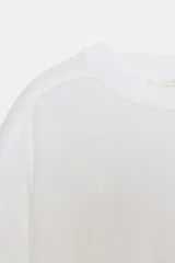 Camiseta de corte holgado confeccionada en algodón, con cuello redondo, manga corta con dobladillo y bajo recto.