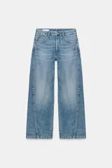 Jeans de tiro medio con corte baggy barrel, cinco bolsillos y costuras laterales curvas. Cierre frontal con cremallera y botón metálico.