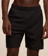 Bermuda deportiva gris con cintura elástica, cordón de ajuste, bolsillos con cremallera, recorte lateral con agujeritos y abertura en el bajo.