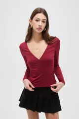 Remera de manga larga color bordó, con escote en V profundo y ajuste al cuerpo.