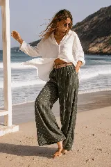 Pantalón de lino azul marino con finas rayas verticales blancas, de corte amplio y talle alto. Incluye bolsillos funcionales y una cintura elástica con cinturón de rafia desmontable.