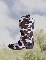 Botas de cuero color marrón y blanco con bordados negros, de estilo cowboy con taco bajo.