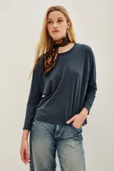 Remera azul oscuro de algodón peruano con textura jaspeada, de moldería holgada y buena caída, con mangas largas que se ajustan hacia la muñeca y se ensanchan debajo del brazo.