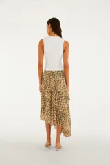 Falda midi de gasa liviana con volados asimétricos superpuestos, abertura lateral y cintura alta, con estampa geométrica en tonos verdes y naranjas.