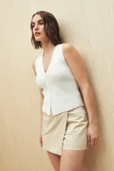 Short pollera color marrón de tiro alto, confeccionado en algodón. Presenta solapa frontal que simula una falda y bolsillos delanteros.