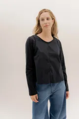 Remera de manga larga color negro, con escote en V, detalle de doble entredos en la sisa y confección combinada de algodón en la parte delantera y remería en la espalda para mayor elasticidad.