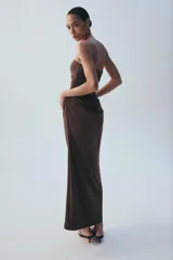 Vestido midi de escote recto sin tirantes, color marrón, con diseño semitransparente en la sección del abdomen y detalle drapeado en la falda. Cuenta con cierre lateral.