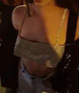 Top dorado con lentejuelas, breteles finos y espalda descubierta con cierre de cadenita.