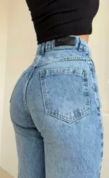 Jean de tiro alto en color azul claro, con diseño de cintura cruzada asimétrica y tajos laterales en el ruedo.