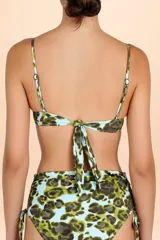 Top de bikini estilo bandeau con estampado animal print sobre fondo turquesa, decorado con incrustaciones metálicas brillantes y breteles finos.