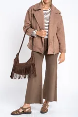 Campera de abrigo color crema, con cuello solapa y cierre asimétrico frontal. Presenta textura bouclé o de lana rizada.