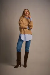 Camisa celeste a rayas verticales blancas, de corte oversize, manga larga y puños anchos.