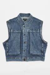 Chaleco de denim estilo utility con diseño oversized, bolsillos cargo frontales y cierre con botones metálicos. Presenta un lavado tipo washed.
